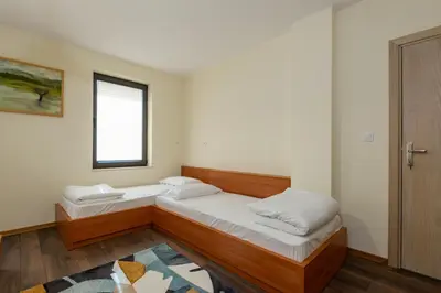 a room with two beds and a window at ВИЛА МАРИНОВИ in Boykovo