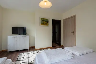 a bedroom with a bed and a flat screen tv at ВИЛА МАРИНОВИ in Boykovo