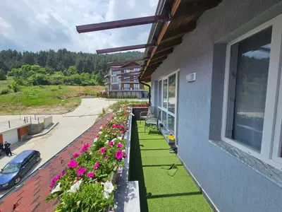 a balcony with flowers on the side of a building at Апартамент за гости Боляри in Velingrad