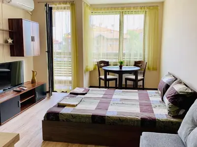 a bedroom with a bed and a table with chairs at Studio El - All seasons in Bansko