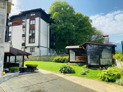 a house with a greenhouse in front of a building at Studio El - All seasons in Bansko