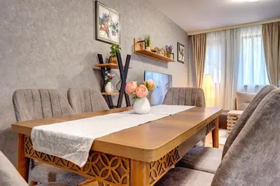 a dining room table with a vase of flowers on it at Luxury Flat in Grand Resort Pamporovo by Flat Mаnager in Pamporovo