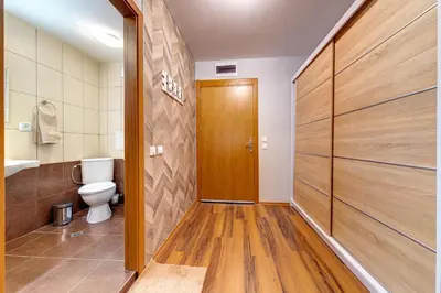 a bathroom with a toilet and a wooden door at Luxury Flat in Grand Resort Pamporovo by Flat Mаnager in Pamporovo