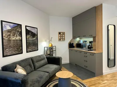 a living room with a couch and a kitchen at Sana Ski apartment 313A in Flora, Borovets in Borovets