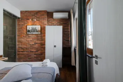 a room with two beds and a brick wall at Designer 1BD Cinématique on Solunska by Flat Mаnager in Sofia