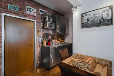 a kitchen with a table and a brick wall at Designer 1BD Cinématique on Solunska by Flat Mаnager in Sofia