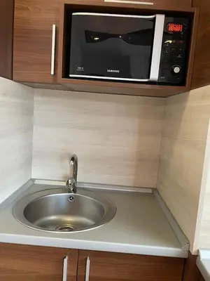 a microwave above a sink in a kitchen at Belvedere Holiday Club ,apartment A202 in Bansko