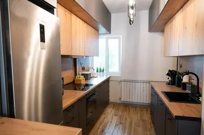 a kitchen with a stainless steel refrigerator and wooden cabinets at Perfect Long-term Stay Stylish and Spacious Top Center Next to Vitosha Blvd in Sofia