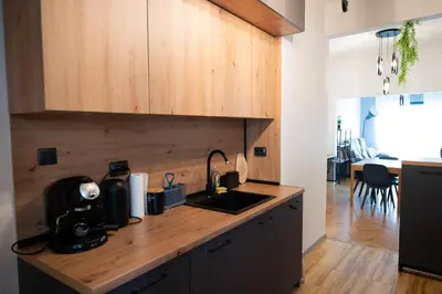 a kitchen with wooden cabinets and a counter top with a sink at Perfect Long-term Stay Stylish and Spacious Top Center Next to Vitosha Blvd in Sofia