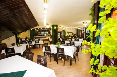 a dining room with white tables and chairs at Почивна станция - ТЕЦ Бобов дол in Bistriza