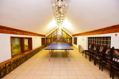 a ping pong table in a room with chairs at Почивна станция - ТЕЦ Бобов дол in Bistriza