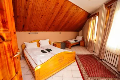 a bedroom with a bed with a wooden ceiling at Почивна станция - ТЕЦ Бобов дол in Bistriza
