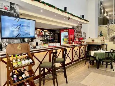 a restaurant with a bar with chairs and a tv at Antonovi Apartments Deluxe in hotel Laplandia in Pamporovo