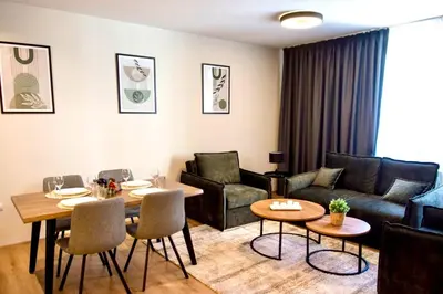 a living room with a couch and a table and chairs at Antonovi Apartments Deluxe in hotel Laplandia in Pamporovo