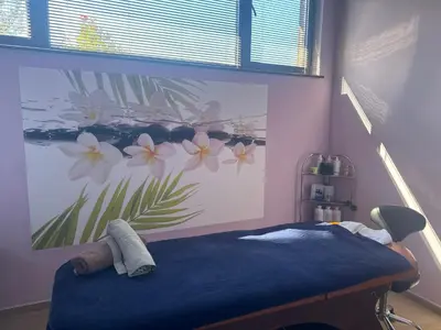 a bedroom with a blue bed with a flower mural on the wall at Alpine Lodge Bansko Apartments in Bansko