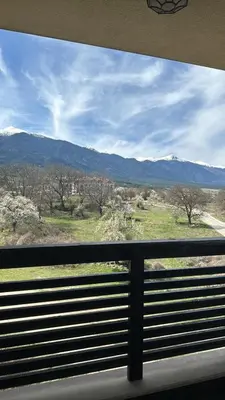 a view from a window of a field and mountains at Alpine Lodge Bansko Apartments in Bansko