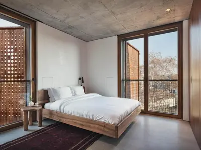 a bedroom with a large bed and large windows at DOT Sofia in Sofia
