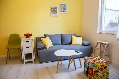 a living room with a blue couch and a table at Apartment Serdika 1 in Sofia