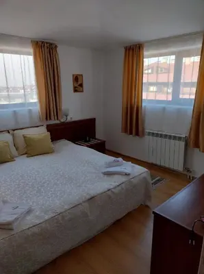 a bedroom with a large bed and two windows at Gondola lift apartment 5401 in Bansko