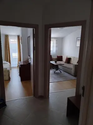 a view of a living room with a couch and a room with a table at Gondola lift apartment 5402 in Bansko