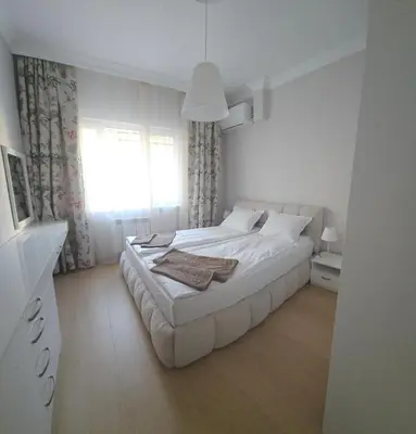 a white bedroom with a bed and a window at Tsar Asen 21 in Sofia
