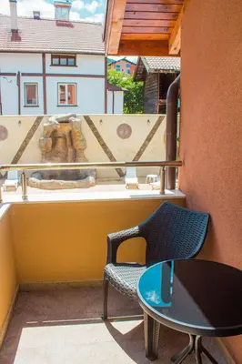 a balcony with a table and chairs and an elephant on a building at Guesthouse The Rock in Sapareva Banya