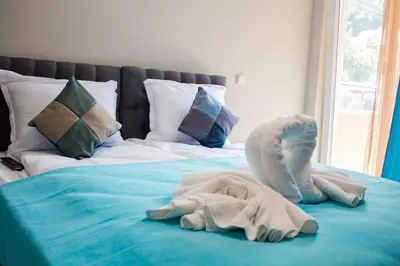 a bed with a pile of towels on it at Guesthouse The Rock in Sapareva Banya