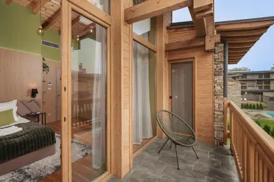 a room with a bed and a chair on a balcony at Luxury Villa with Hot Pool in Banya