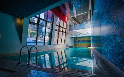 a swimming pool in a building with a large window at Forest nest - your place to rest! in Borovets