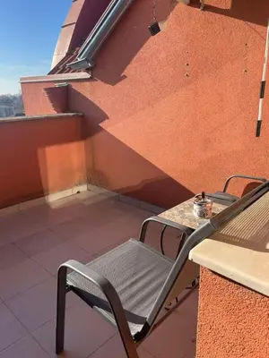 a chair sitting on a balcony with a table at апартамент Римската стена in Hisarya