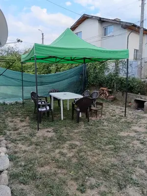 a table and chairs under a green tent at Апартамент Стар стил Old style in Raduil