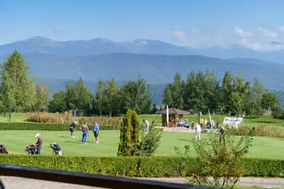a group of people playing golf on a golf course at Pirin Golf Mountain View Retreat in Razlog