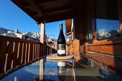 a bottle of wine sitting on a table on a balcony at Pirin Golf Mountain View Retreat in Razlog
