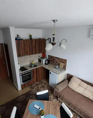 a living room with a couch and a kitchen at Flat Cedar Lodge 2min walk to gondola in Bansko