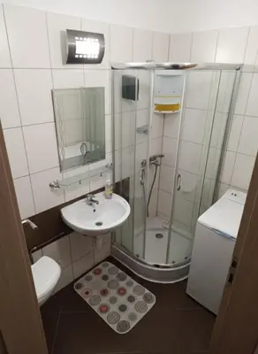 a small bathroom with a shower and a sink at Flat Cedar Lodge 2min walk to gondola in Bansko