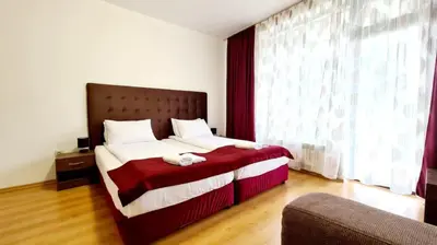 a bedroom with a large bed with a red blanket at Studio Maria in Bansko