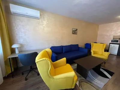a living room with a blue couch and two yellow chairs at Bansko Royal Towers George Apartment, next to the Gongola in Bansko