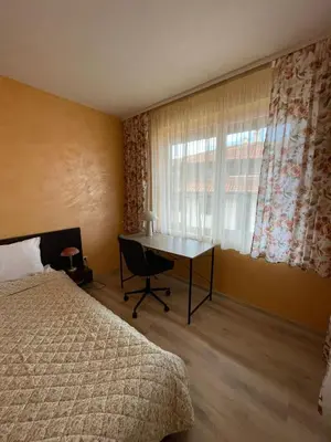 a bedroom with a bed and a desk and a window at Bansko Royal Towers George Apartment, next to the Gongola in Bansko