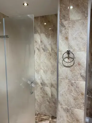 a shower with a glass door in a bathroom at Bansko Royal Towers Thea Apartment, modern renovated bathroom in Bansko
