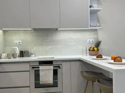 a kitchen with white cabinets and a counter top at Мoka Apartment in Sofia