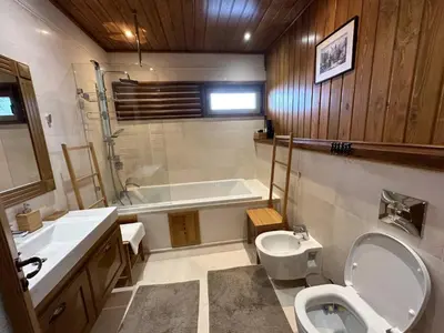a bathroom with a toilet and a tub and a sink at Villa - VALL DI VALL in Pirin Golf & Country Club in Razlog