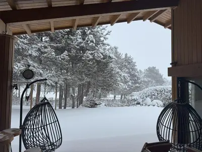 two bird cages on a porch in the snow at Villa - VALL DI VALL in Pirin Golf & Country Club in Razlog