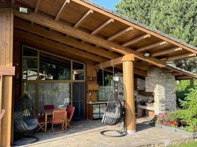 an outdoor patio with a wooden pergola at Villa - VALL DI VALL in Pirin Golf & Country Club in Razlog