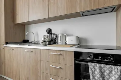 a kitchen with wooden cabinets and a stove top oven at Sofia's Elegant Urban Retreat in Sofia