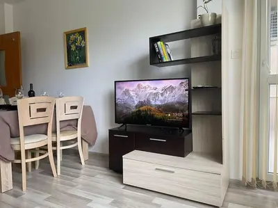 a living room with a television and a table with chairs at Lucky7Lux1 in Pazardzhik