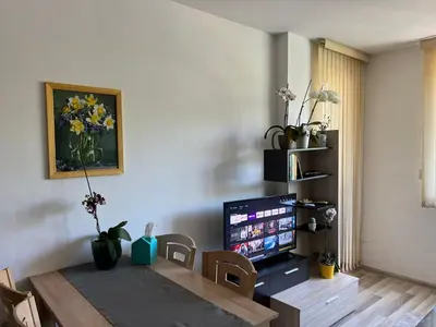a living room with a table and a television at Lucky7Lux1 in Pazardzhik