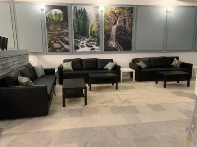 a living room with couches and tables and paintings at Мотел Тихия кът in Sofia