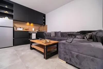 a kitchen and living room with a couch and a table at Chic 1BR Apartment with Balcony in Plovdiv in Plovdiv