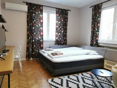 a bedroom with a bed and two windows at Beautifully Decorated Functional Apartment in Sofia