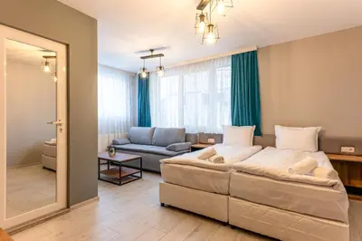 a bedroom with a large bed and a living room at Къща за гости Оскови in Velingrad